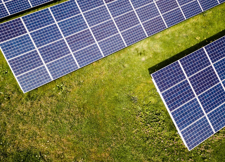 Aerial view of solar panels on green ground